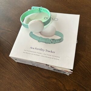 Ava Fertility Tracker with original box, manual, and charging cable.